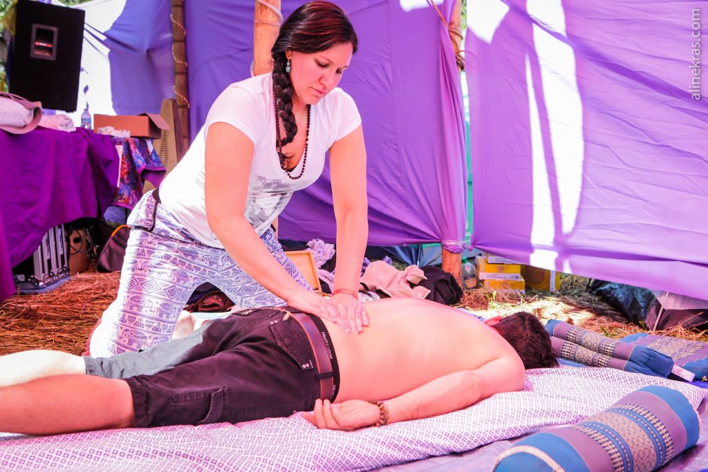 Shirtless man laying face down receiving massage.