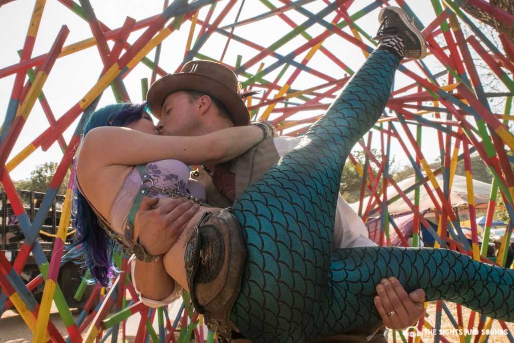 Woman being held up in loving embrace by man and kissed. 